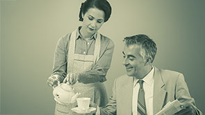 Szene aus den 1960er Jahren: Eine Hausfrau serviert ihrem Mann Kaffee.